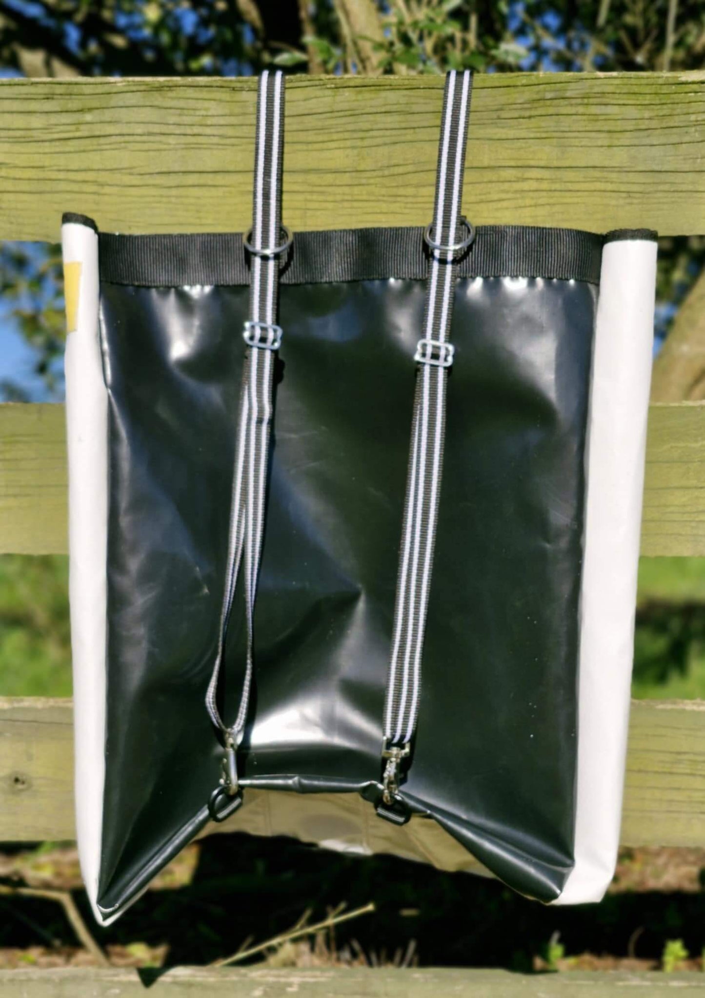 FCR Slow Feed Haybag hanging on a fence, designed for natural foraging and reducing hay waste.