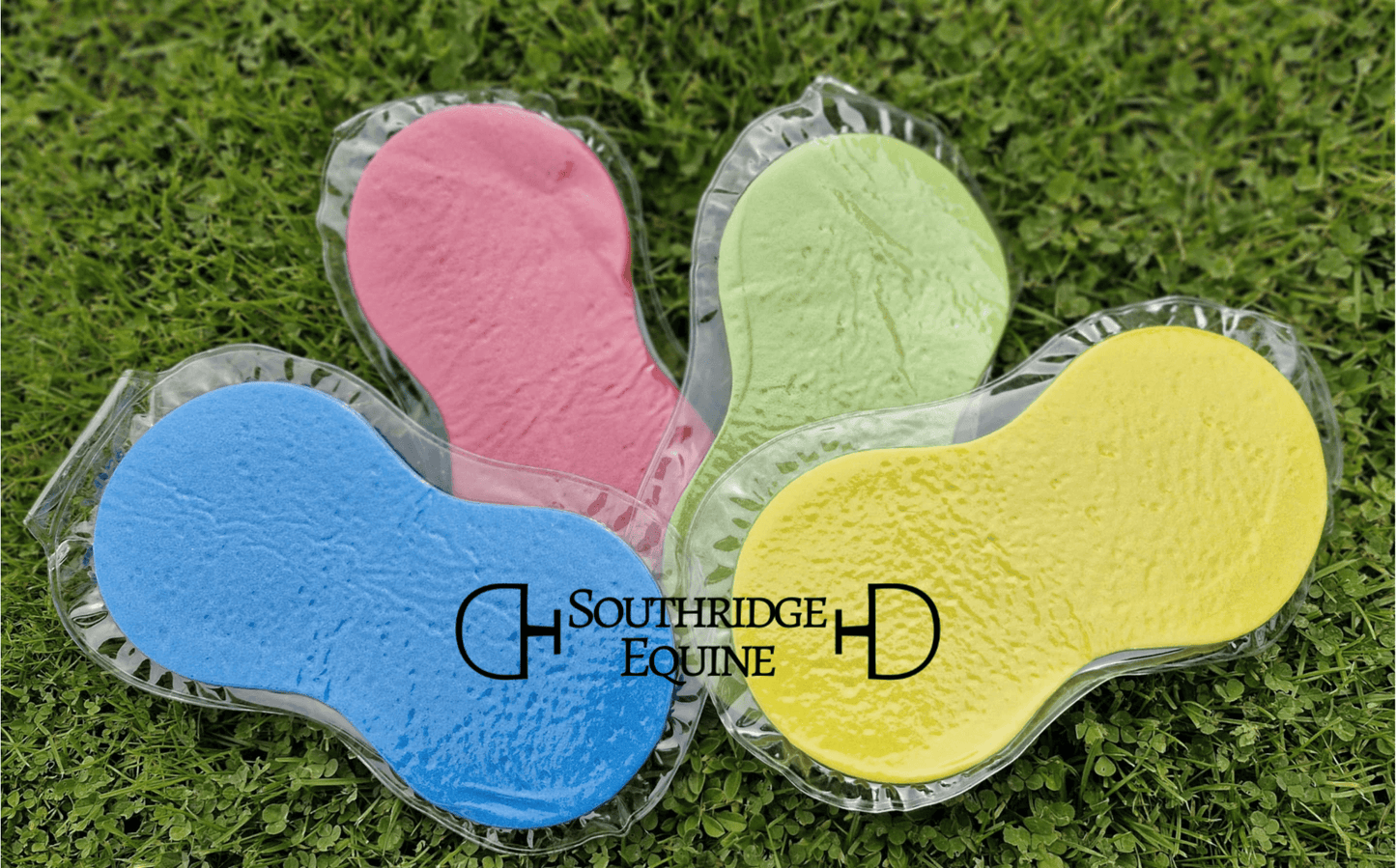 Colorful SE Expanding Sponges in pink, green, blue, and yellow on grass, perfect for equine grooming.